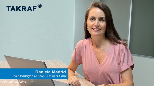 A woman sitting in front of a desk and her PC. She is the HR manager of TAKRAF Chile and Peru.