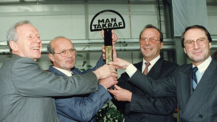 4 people open the new plant and hold up a symbolic key